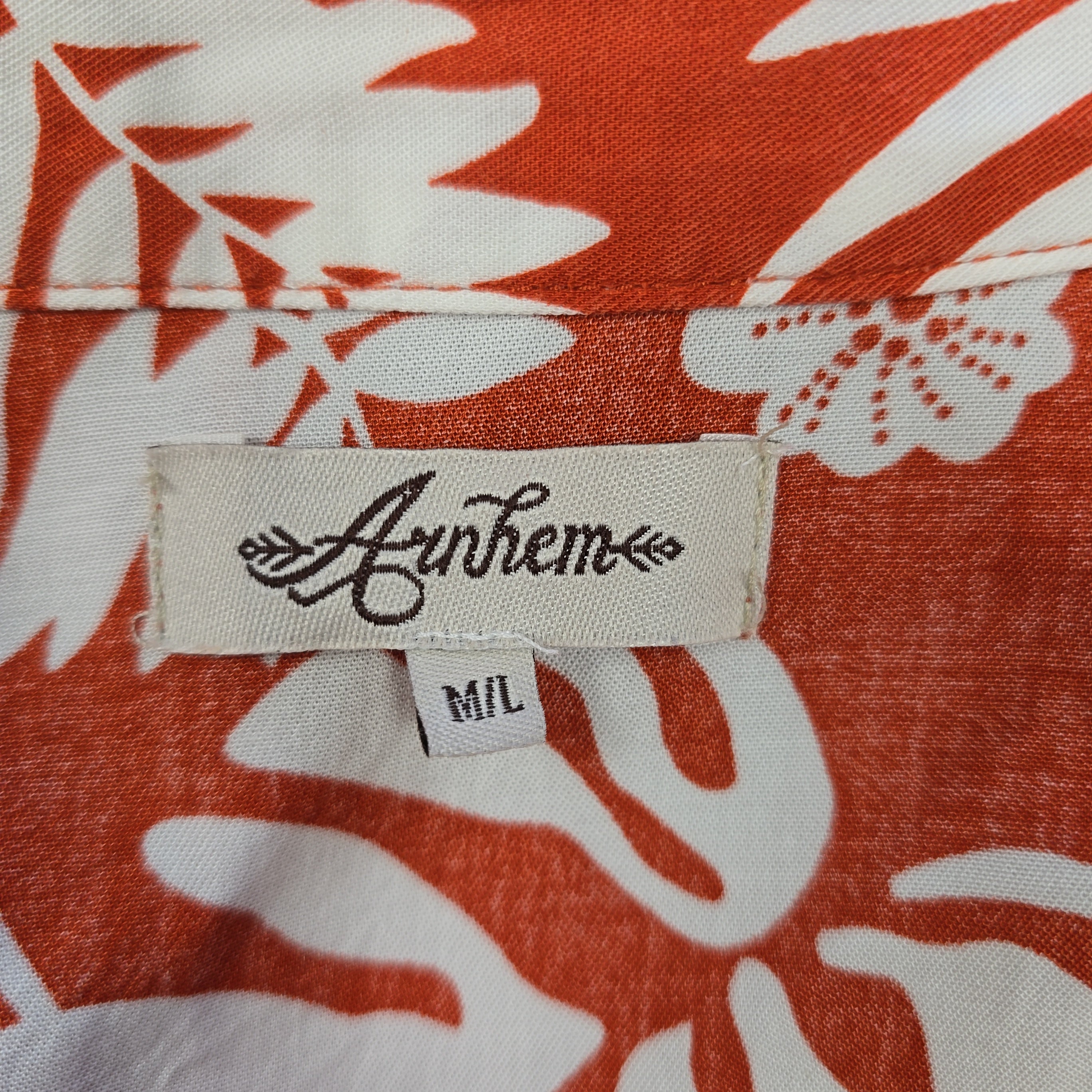 Fabric tag with 'Anthem' branding on a red and white floral patterned fabric.