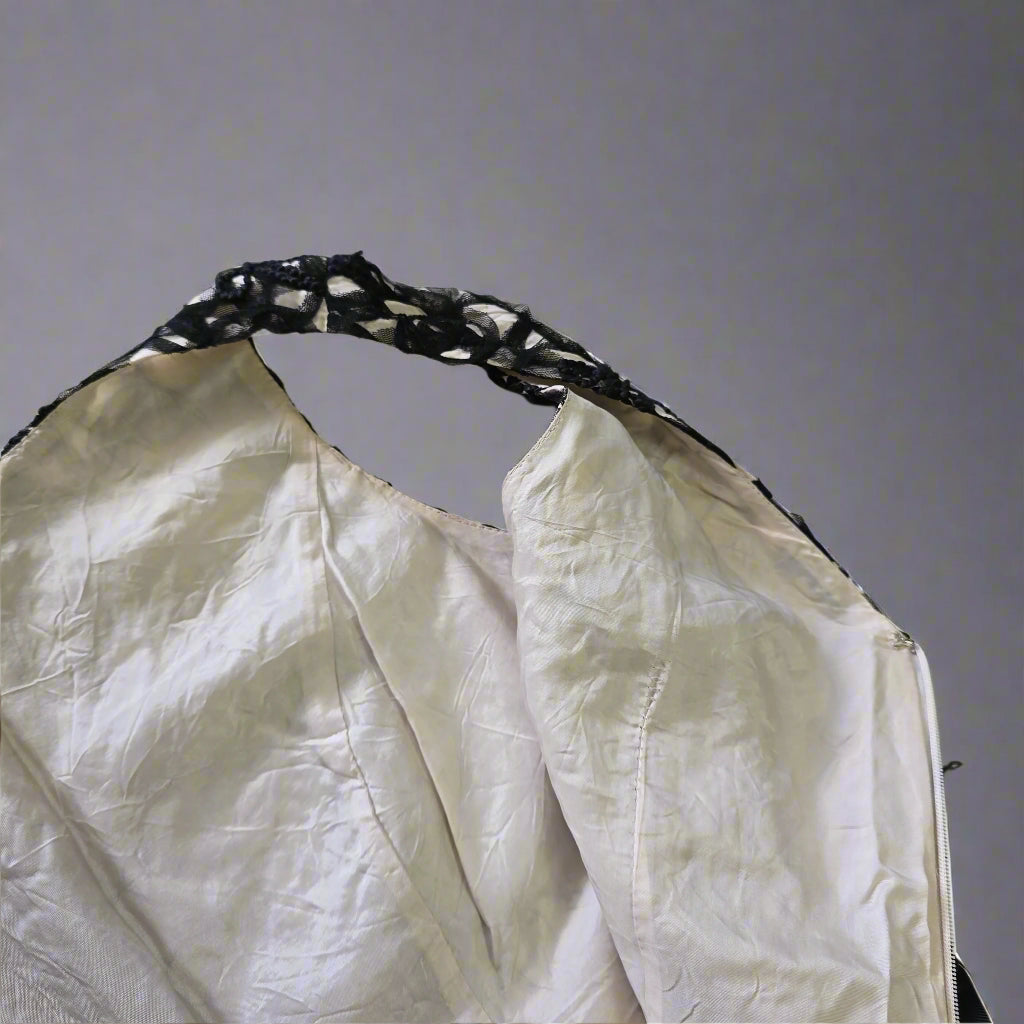 White fabric with black lace trim on a tiled floor