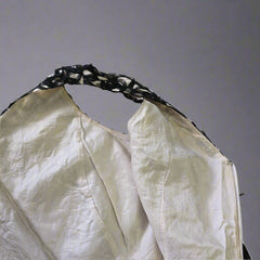 White fabric with black lace trim on a tiled floor