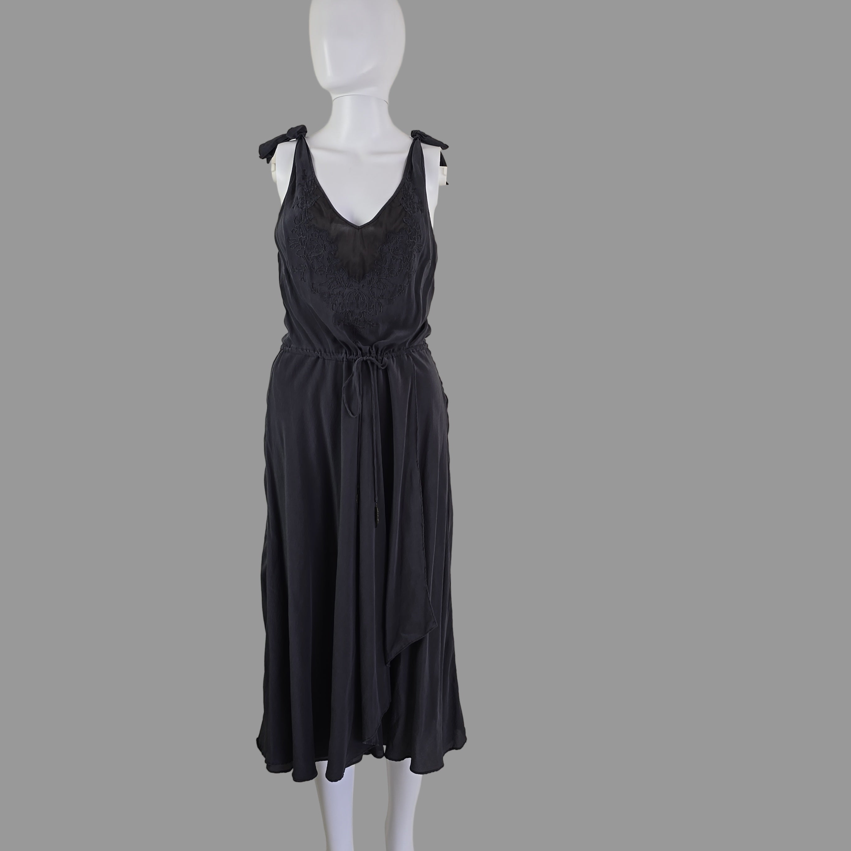 Grey dress on a mannequin against a plain background