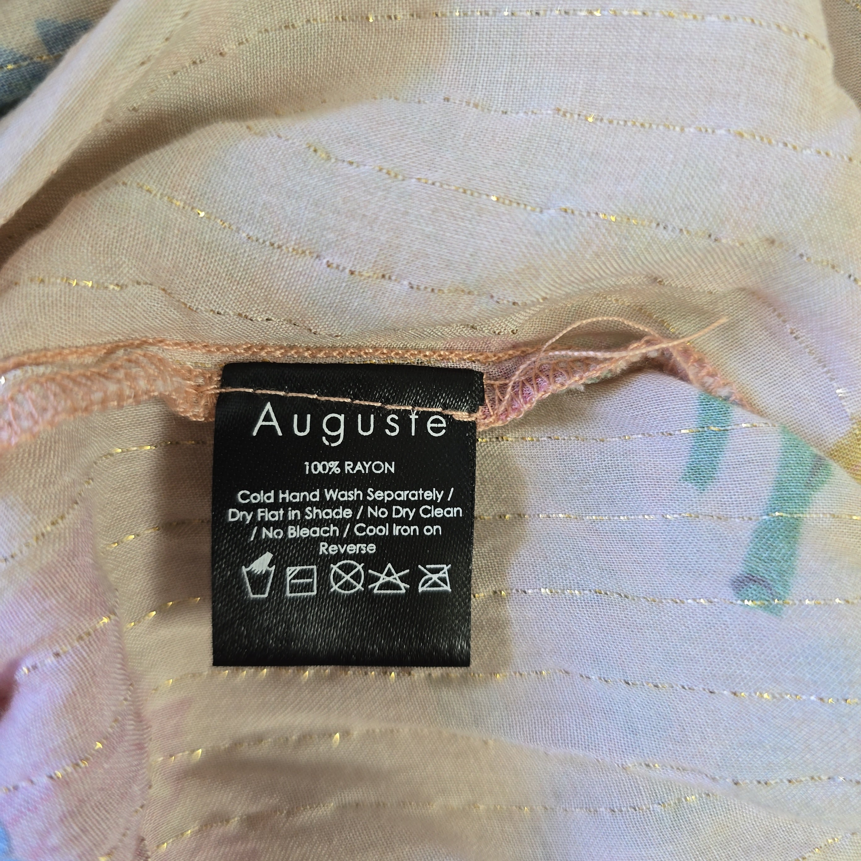 Clothing label with 'Auguste' brand on fabric background