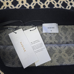 SHEIKE clothing tags on a patterned fabric background