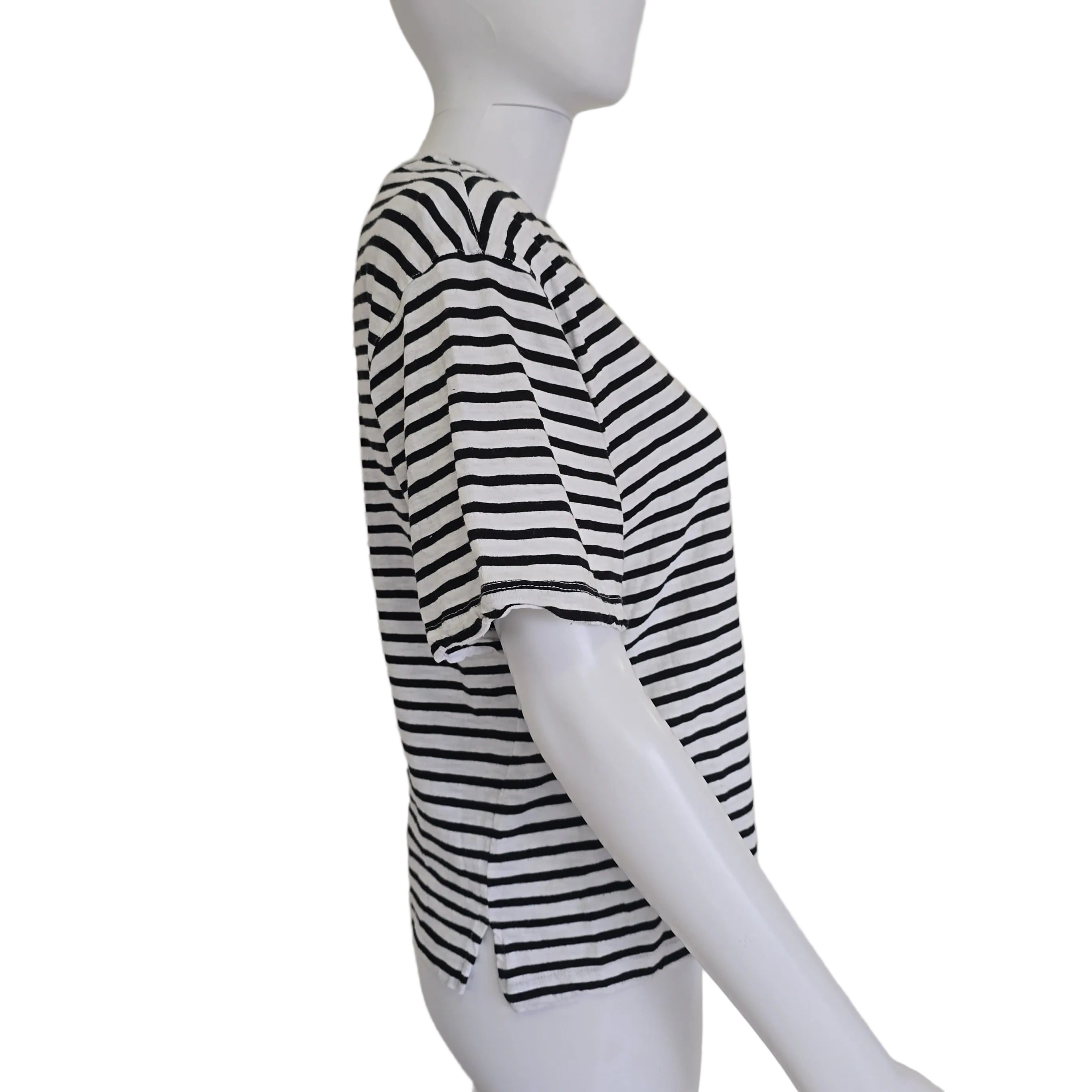 Mannequin wearing a black and white striped garment on a plain background