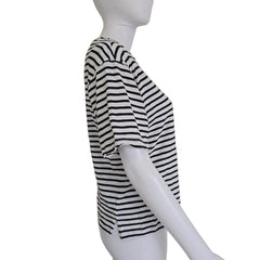 Mannequin wearing a black and white striped garment on a plain background