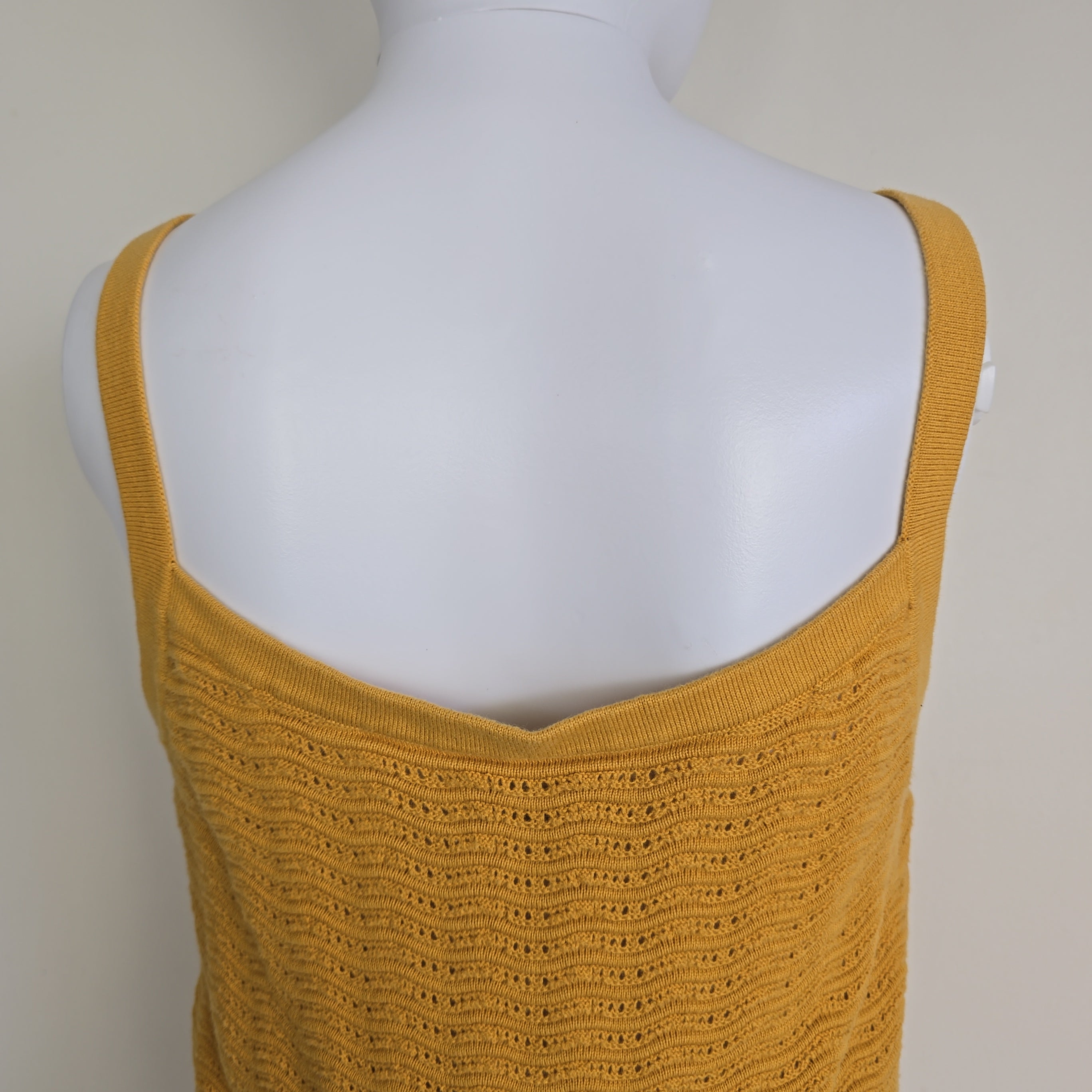 Yellow textured tank top on a mannequin against a neutral background