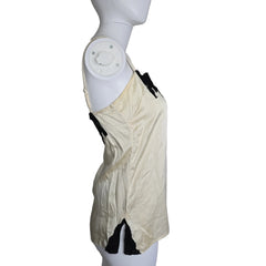 Mannequin wearing a white top with black lace details on a plain background
