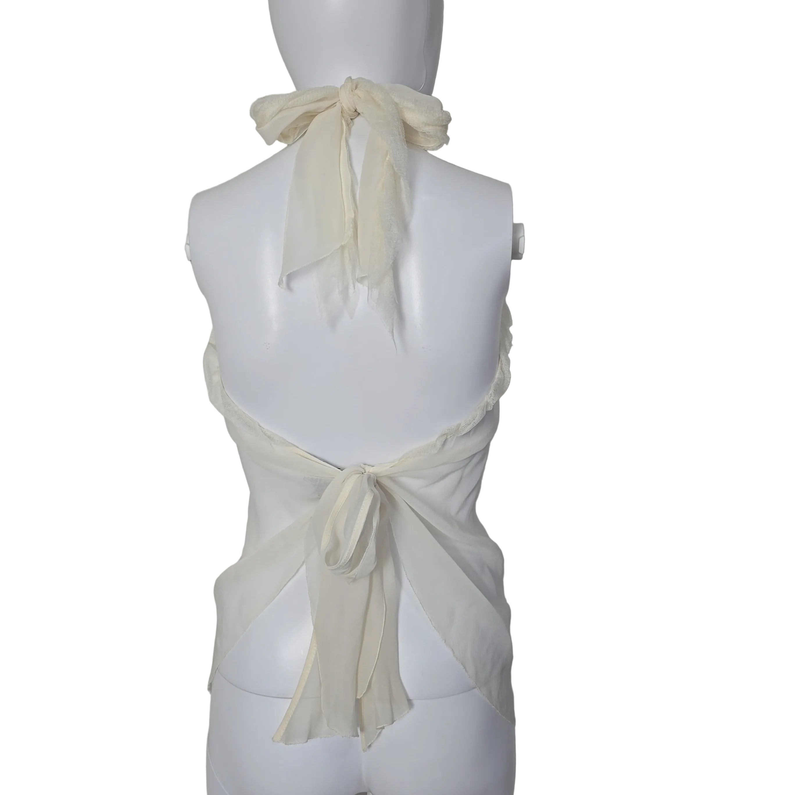 Mannequin wearing a white top with sheer sleeves against a plain background