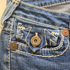 Close-up of a blue denim with buttons and stitching details.