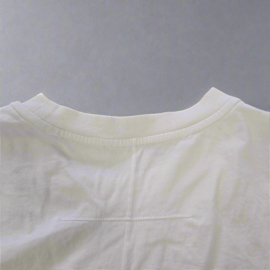 White sleeveless top on a beige tiled floor