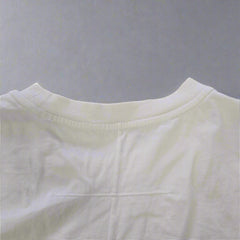 White sleeveless top on a beige tiled floor