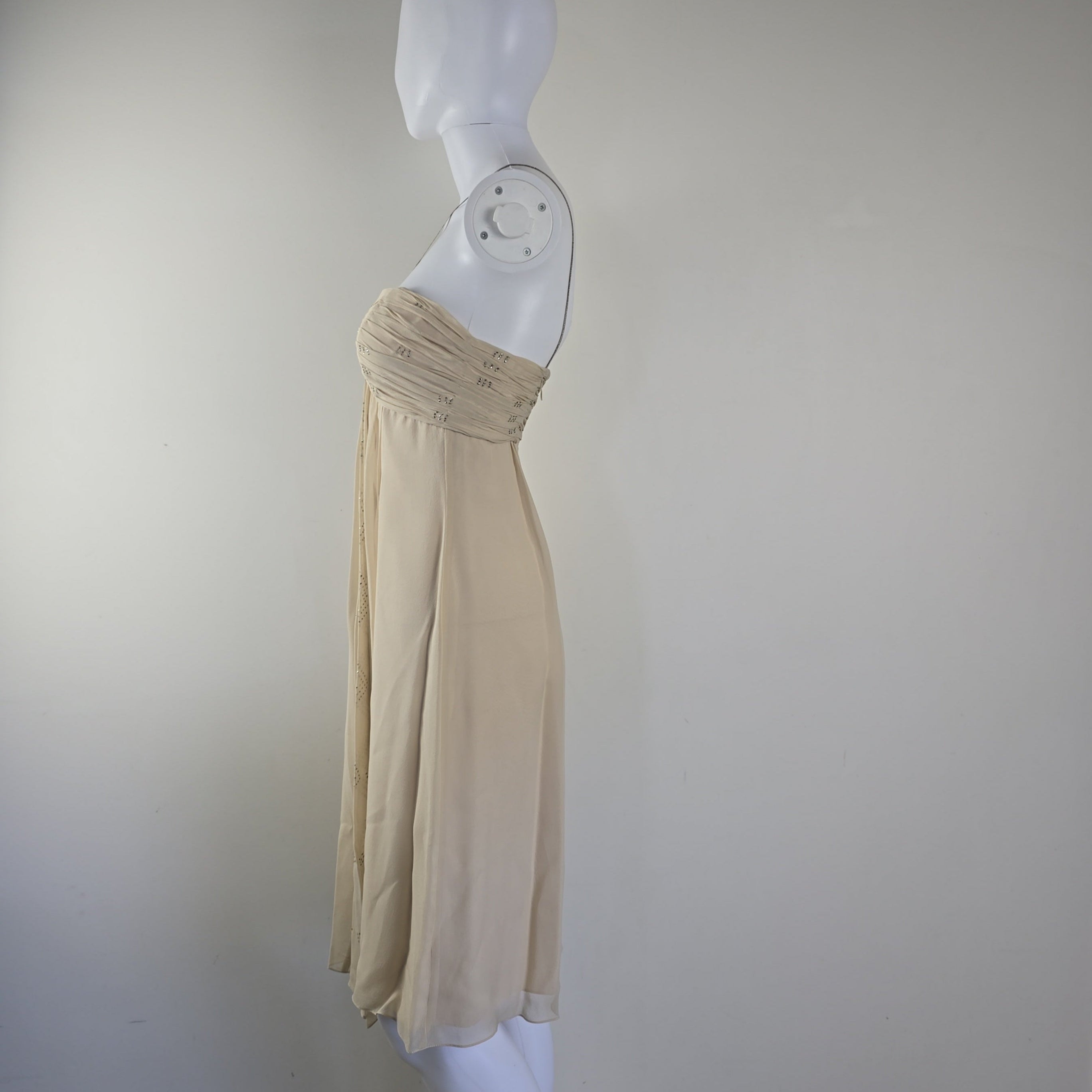 Beige strapless dress on a mannequin against a white background