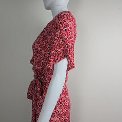 Red patterned dress on a mannequin against a gray background