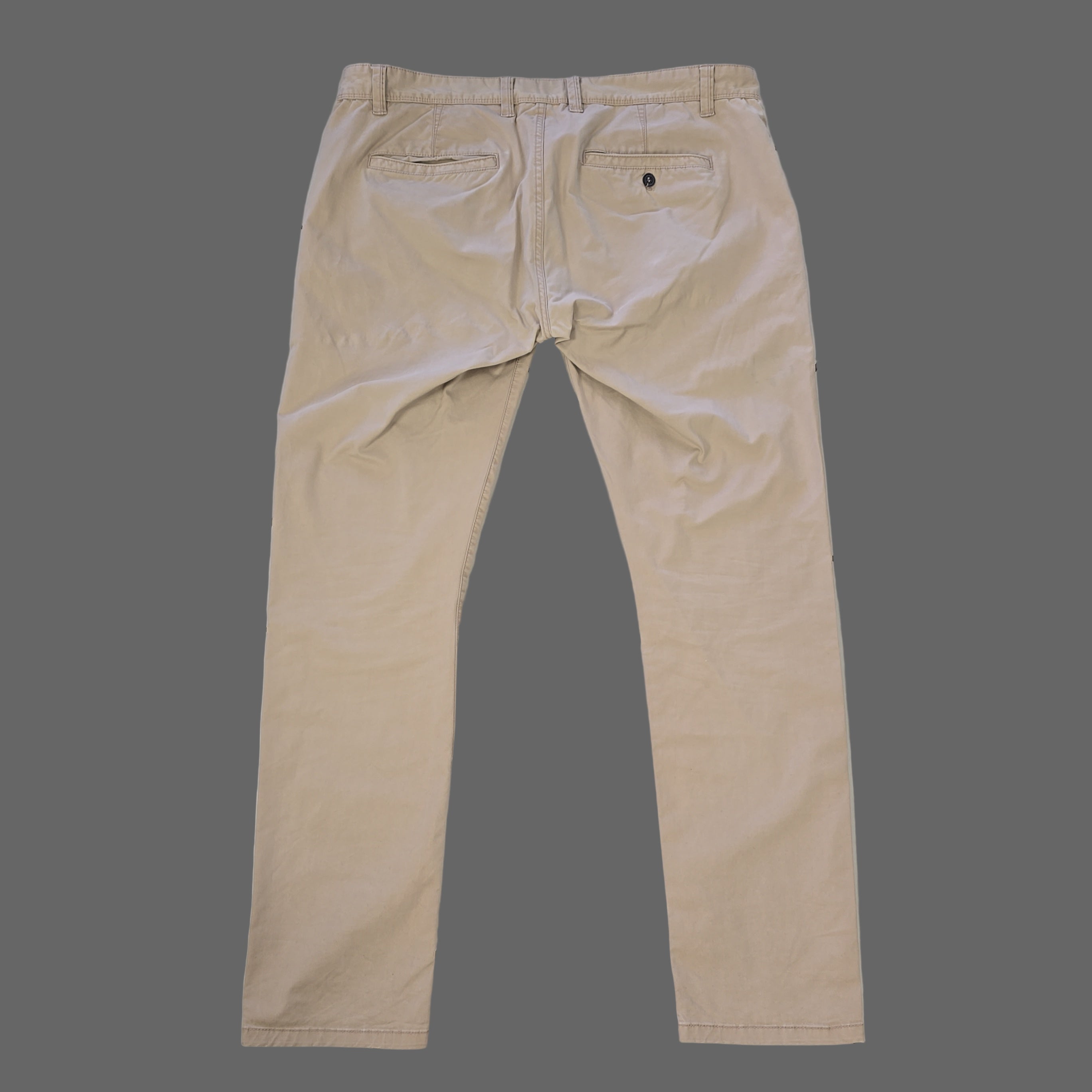 Beige pants laid flat on a tiled floor