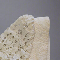 Close-up of a white lace garment on a neutral background