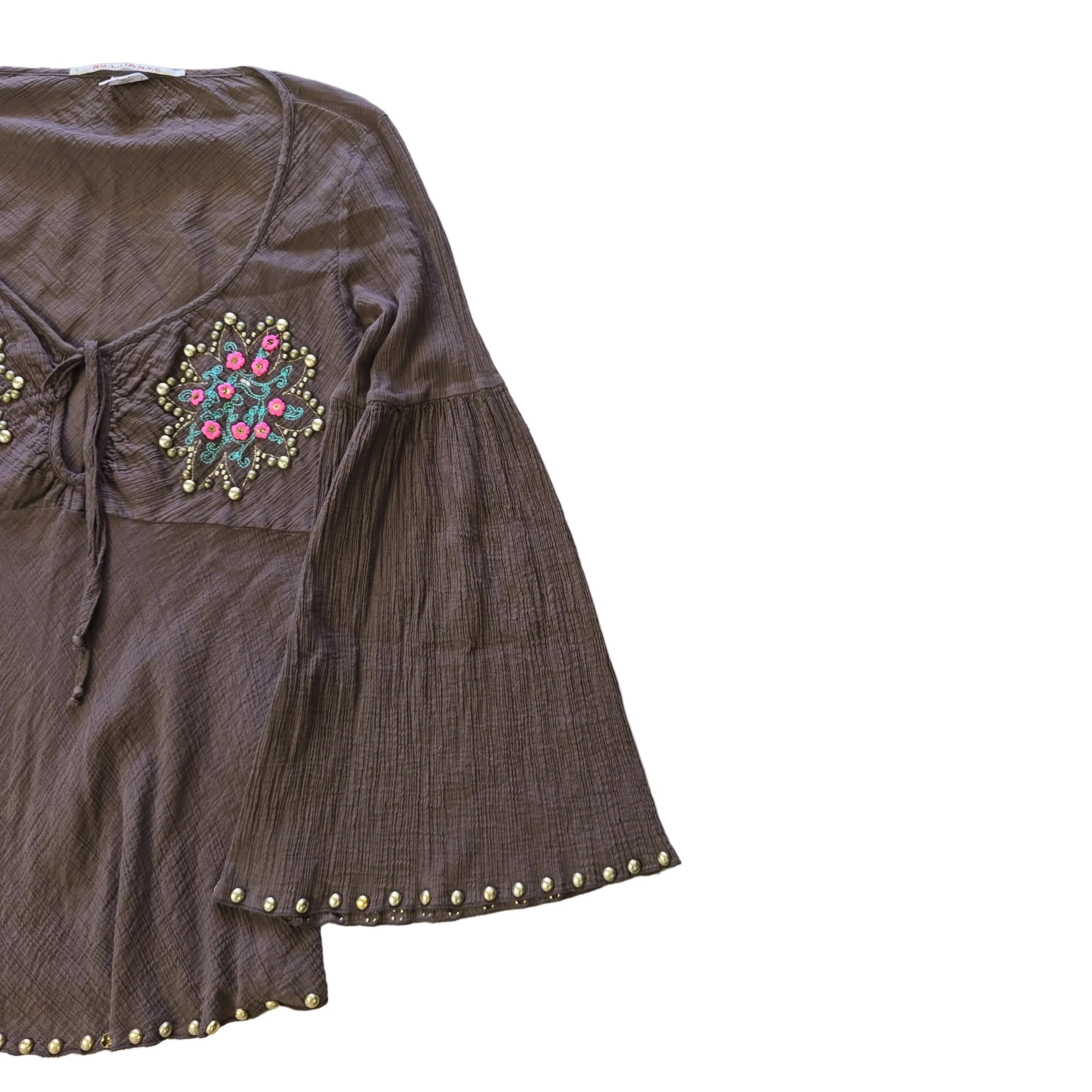 Brown garment with floral embroidery and gold studs on a light background