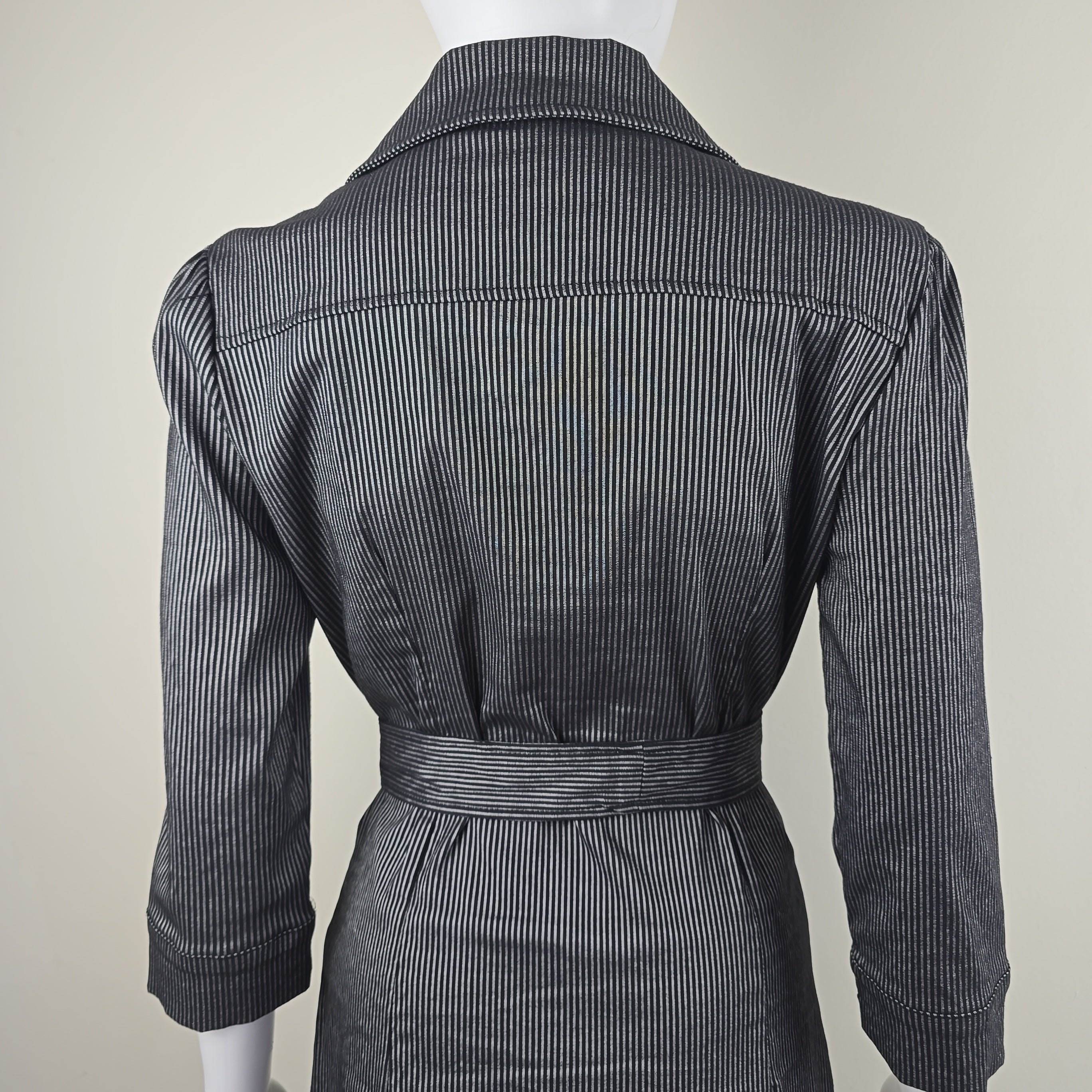 Black pinstripe suit jacket and pants on a mannequin against a white background