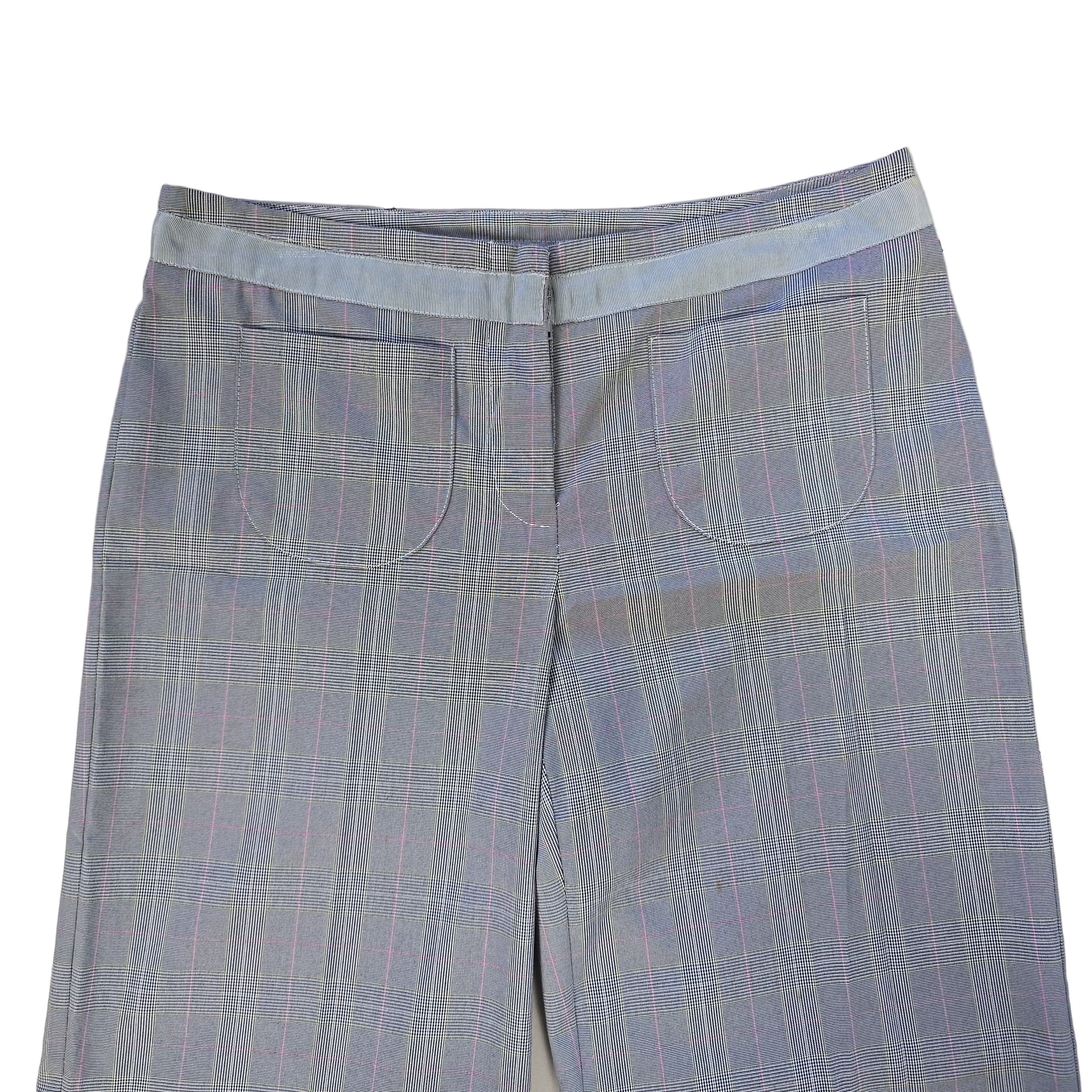 Folded blue checkered pants on a tiled floor