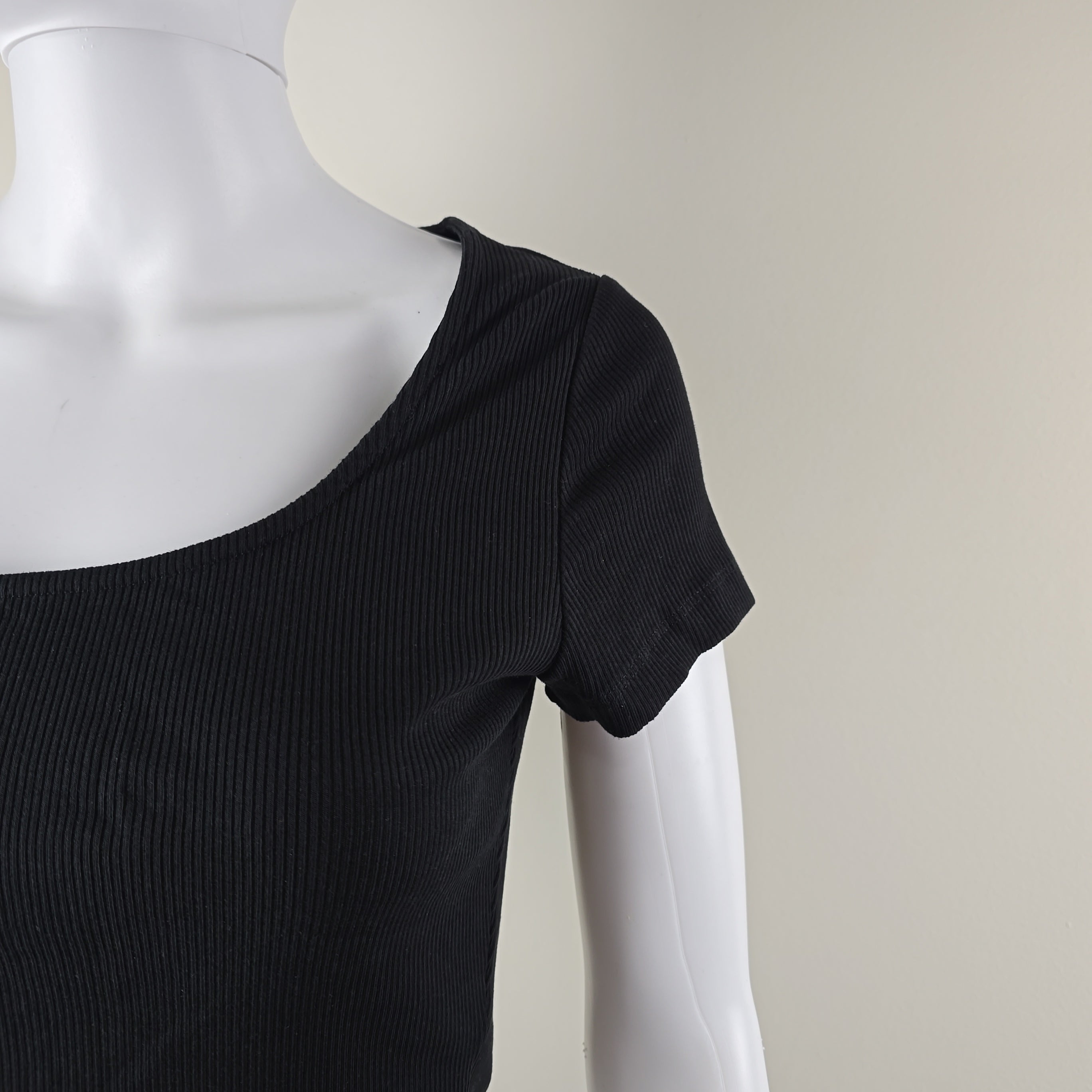 Black sleeveless top on a mannequin against a plain background
