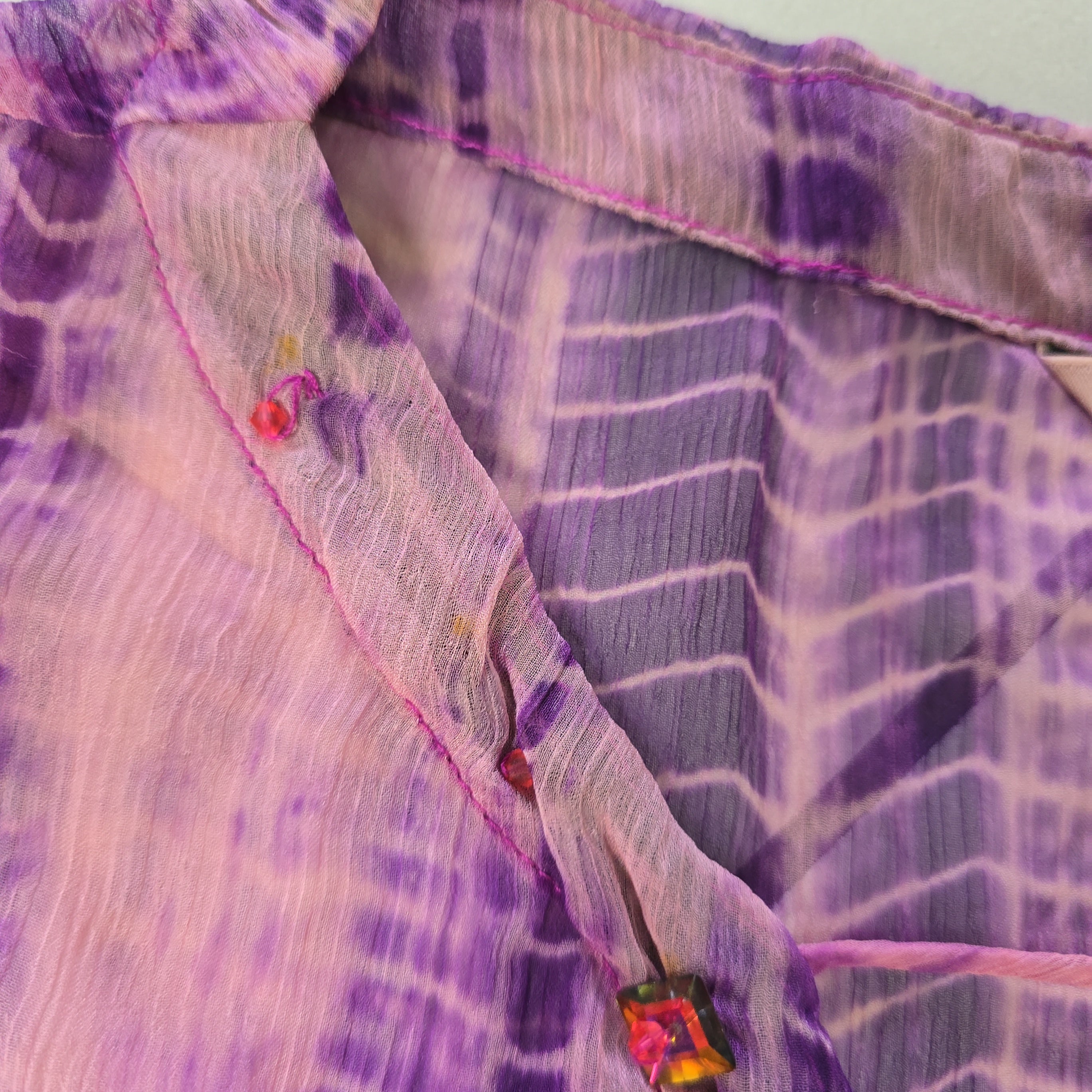 Close-up of a purple and white patterned fabric with a button.