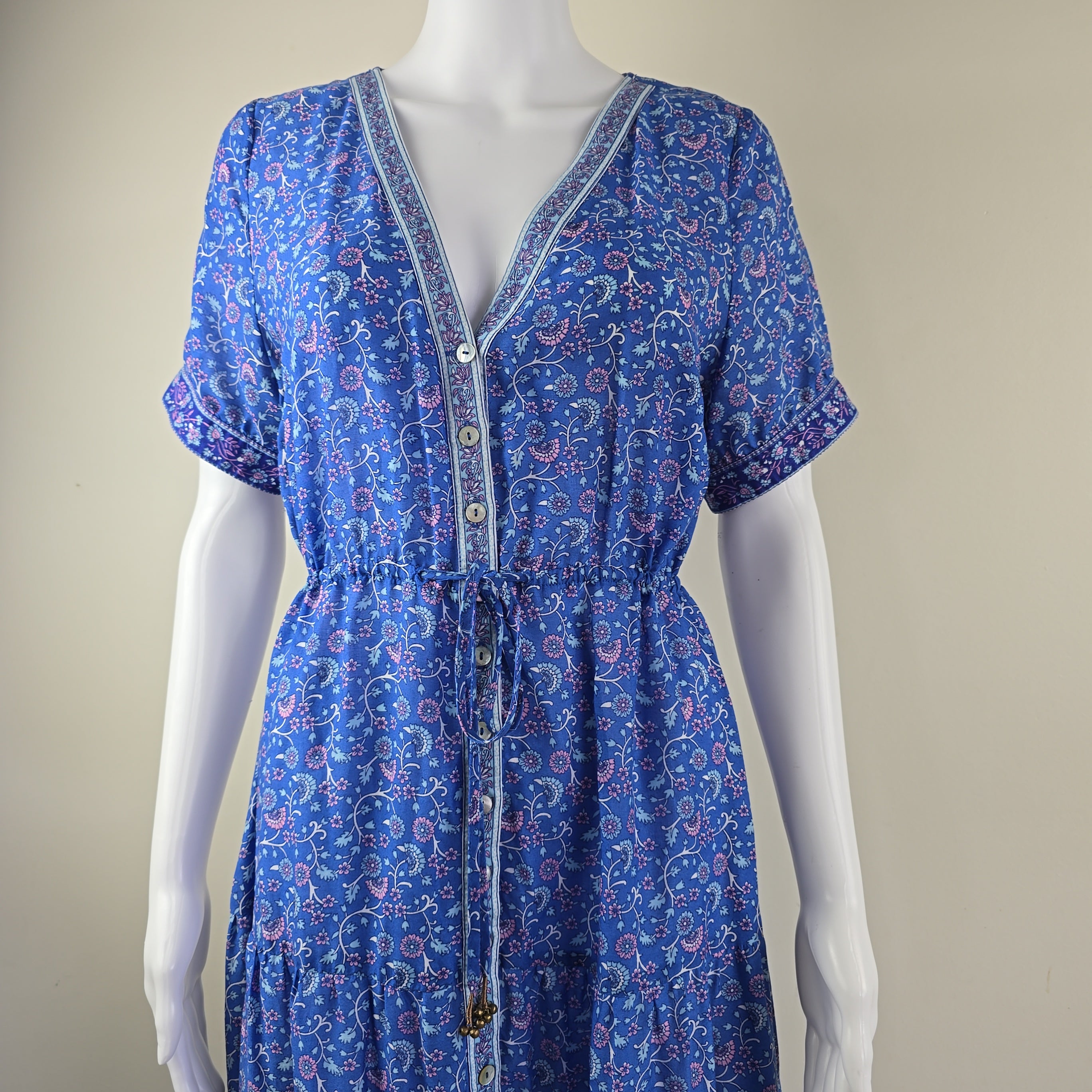 Blue patterned dress on a mannequin against a neutral background