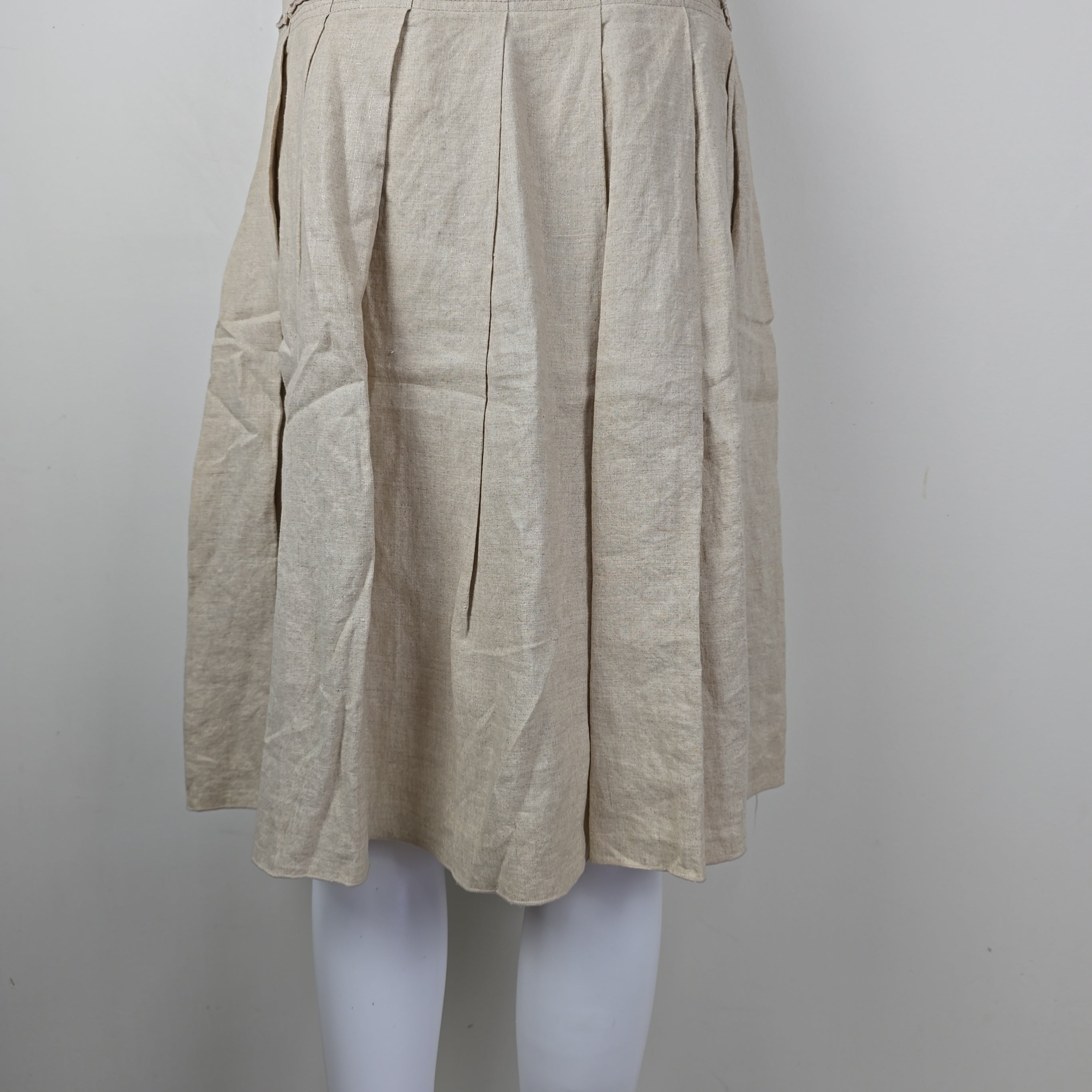 Stack of beige skirt on a white surface with a gray background