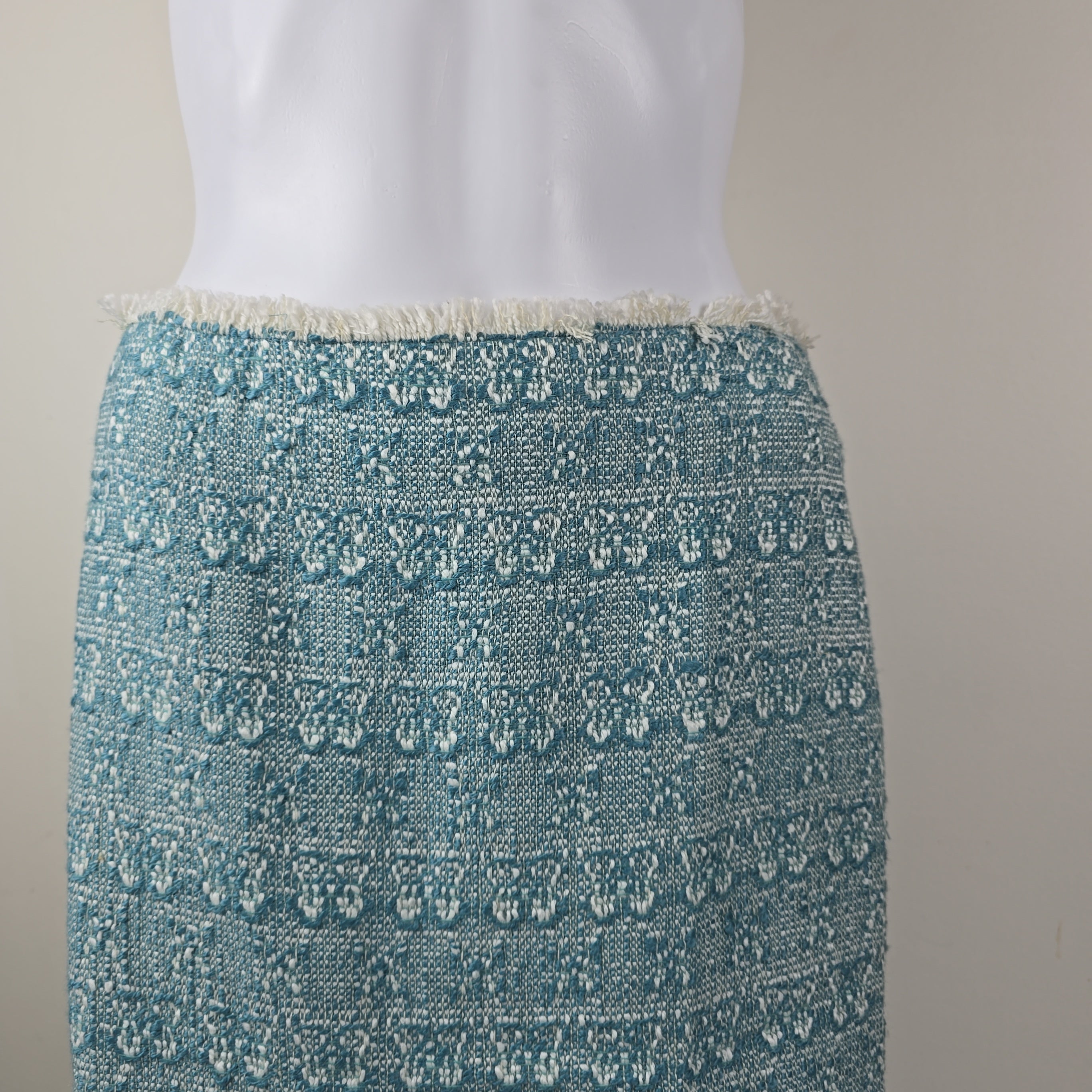 Teal textured fabric with white trim on a neutral background