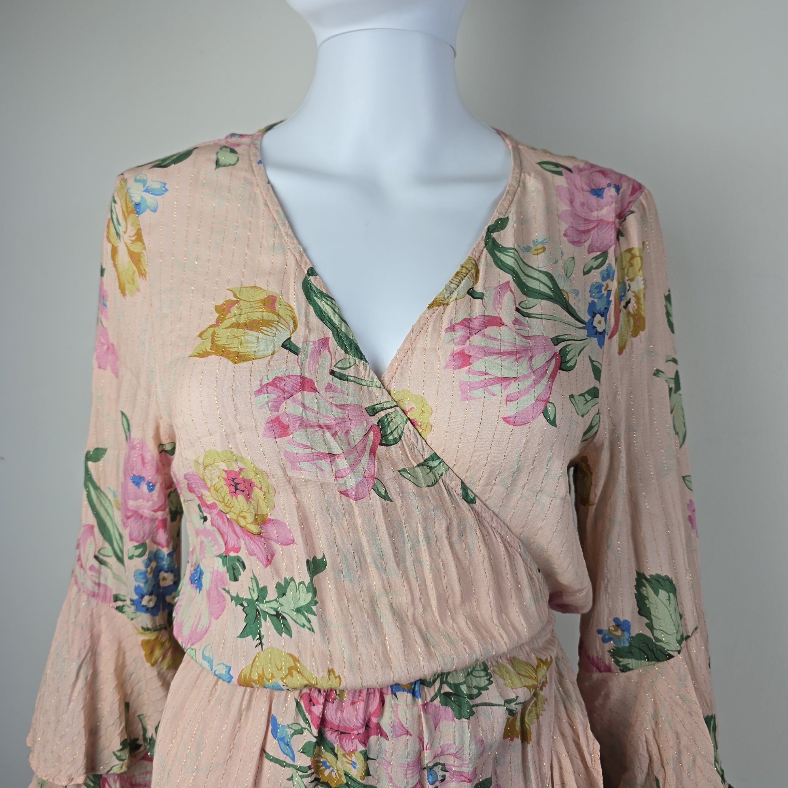 Floral-patterned fabric draped over a mannequin on a plain background