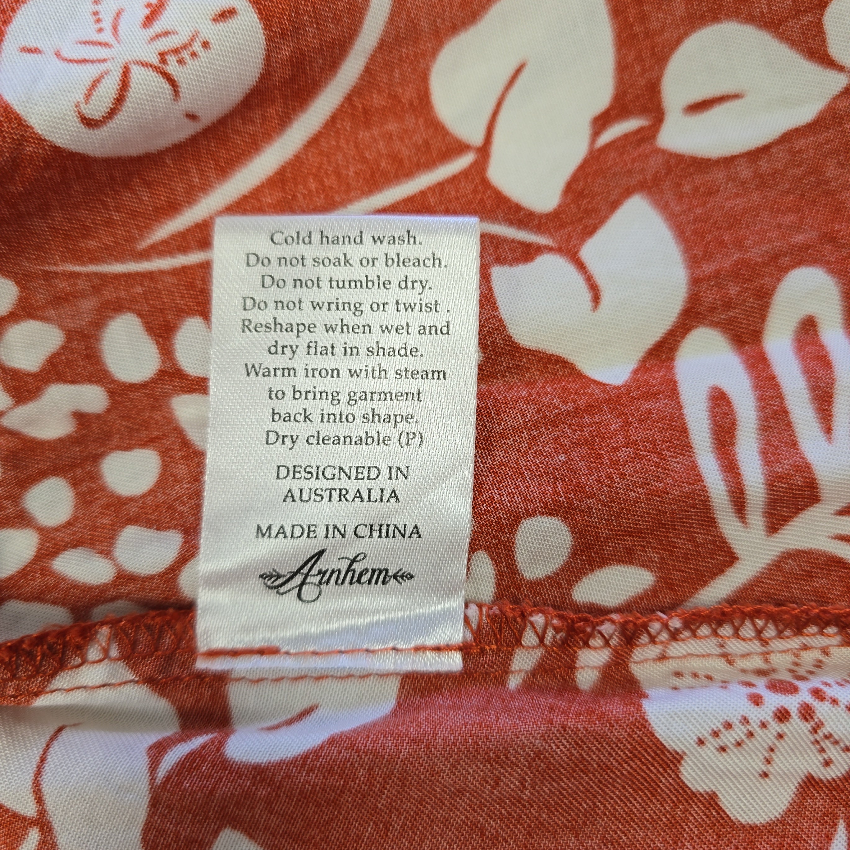 Fabric with a floral pattern and a label on an orange background