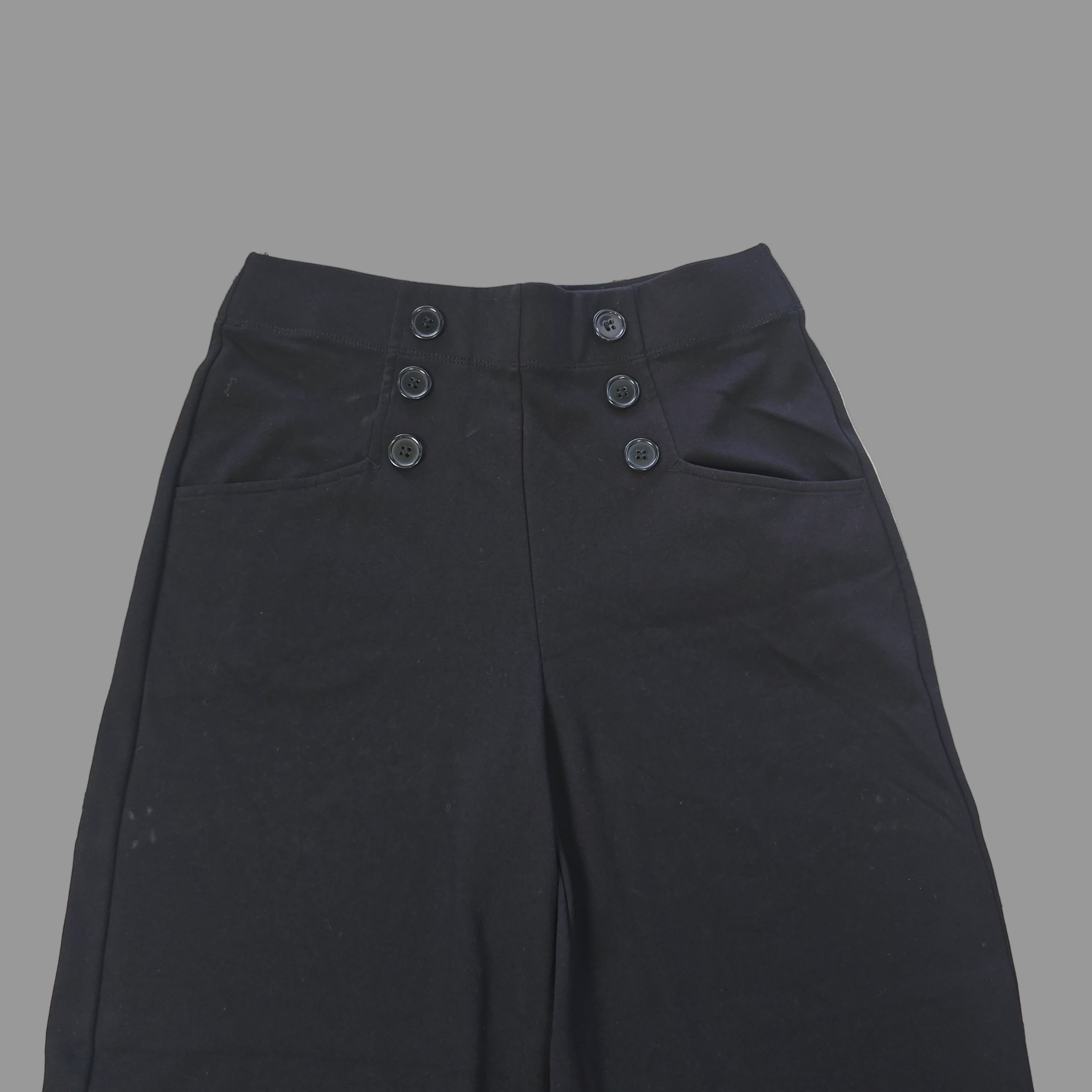 Black button pants details on a tiled floor