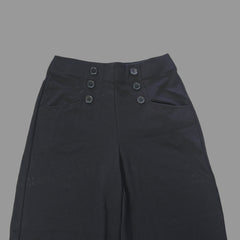 Black button pants details on a tiled floor