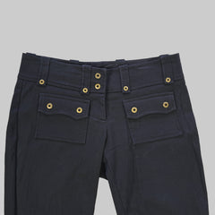 Black pants with gold buttons on a tiled floor