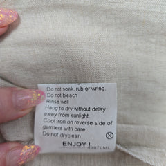 Clothing label on a fabric background with a hand holding it.