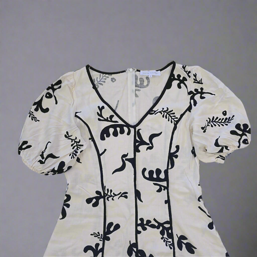 White garment with black floral patterns on a tiled floor