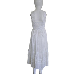 White textured dress on a mannequin against a plain wall