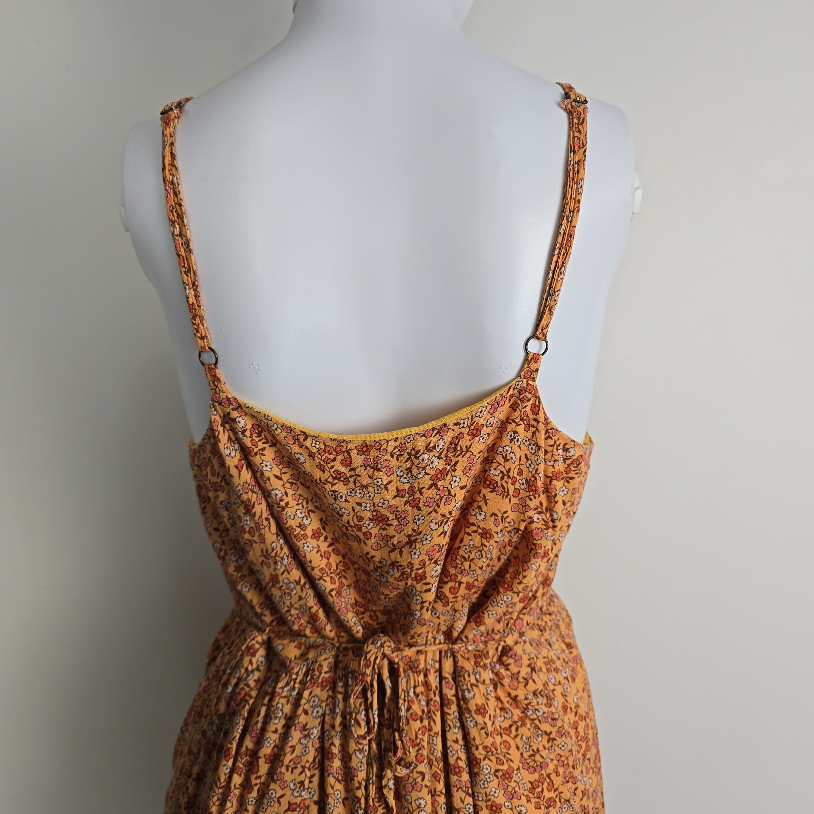 Brown floral dress on a mannequin against a gray background