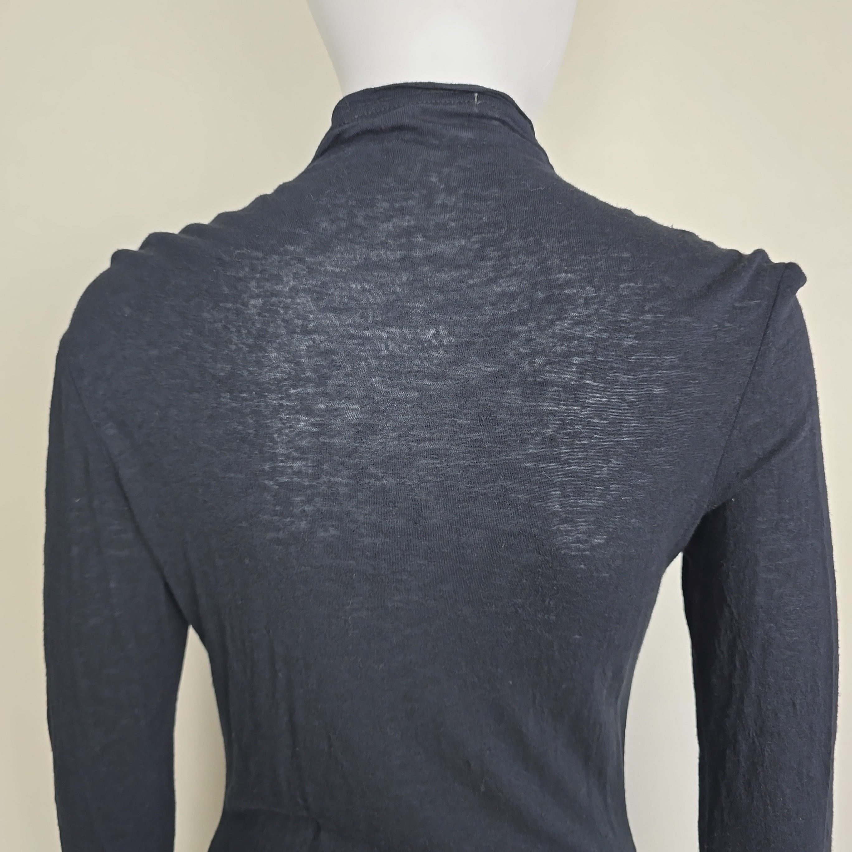 Black top with long sleeves on a light background