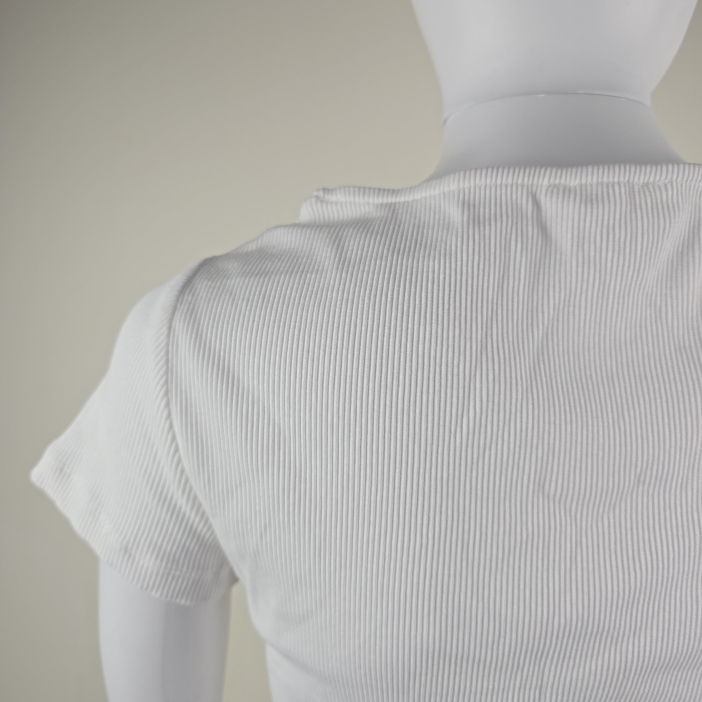 Close-up of a white shirt with thin stripes on a beige background