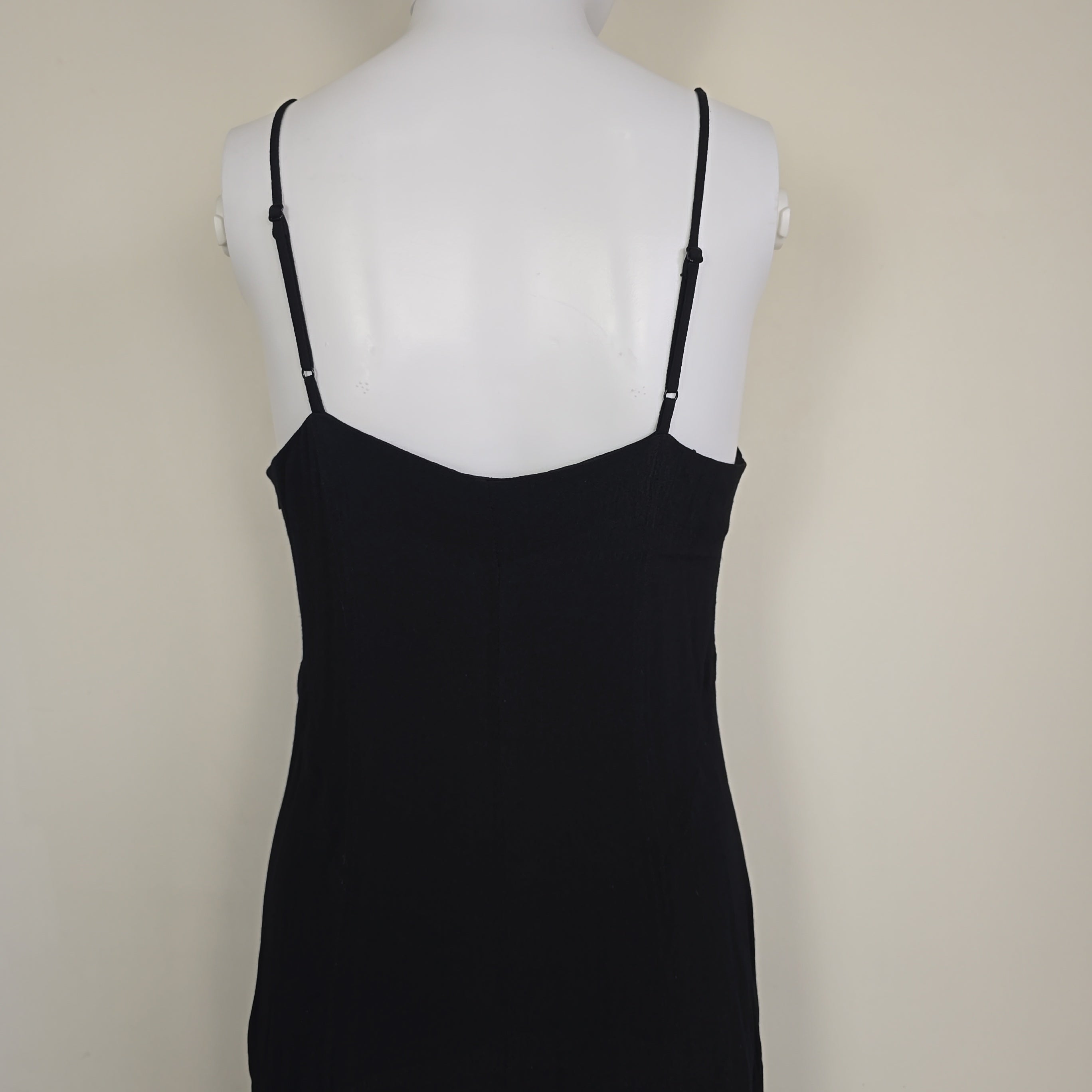 Black dress on a mannequin against a beige background