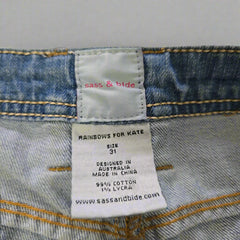 Close-up of a label on denim fabric with text and branding details.