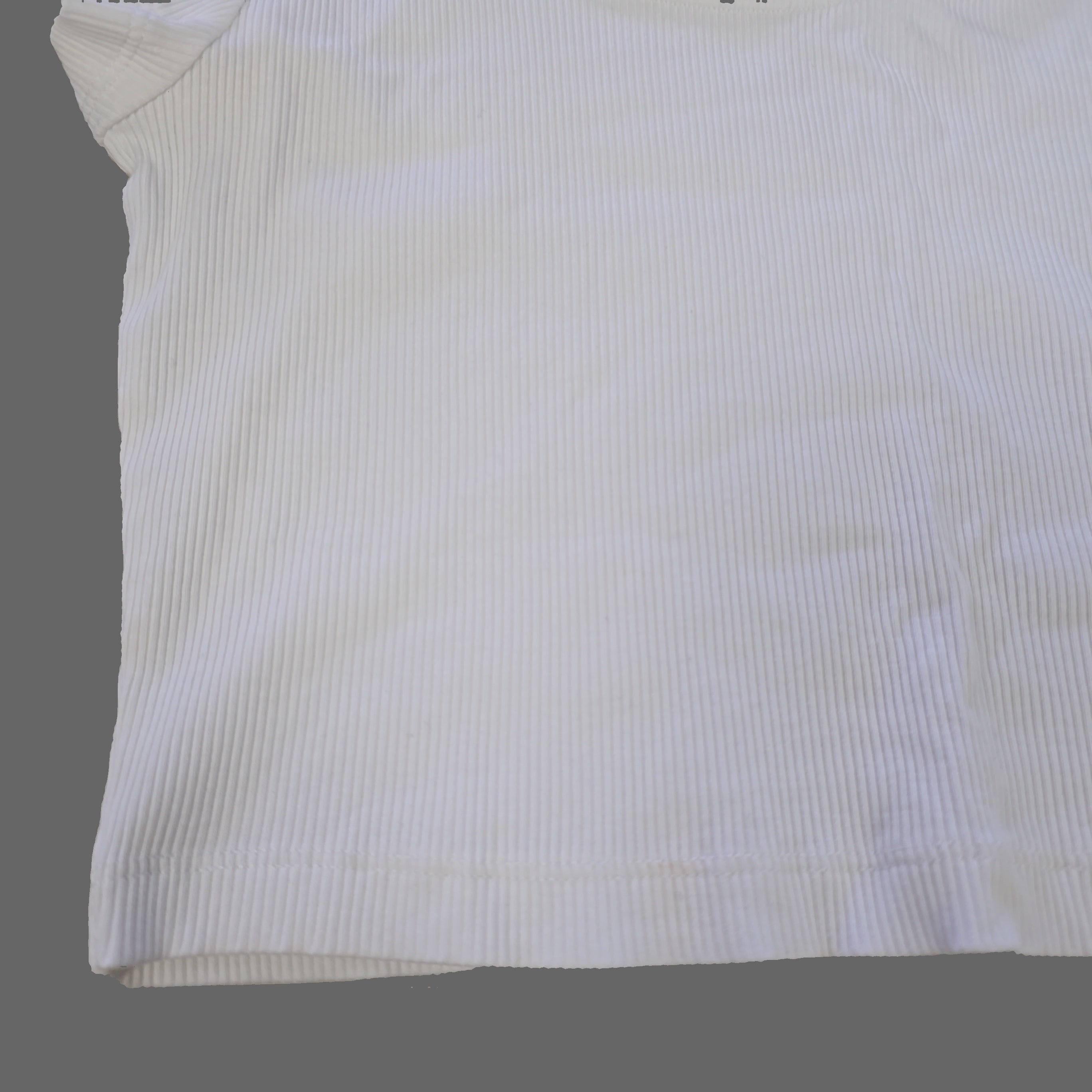 White fabric with subtle pattern on a beige surface