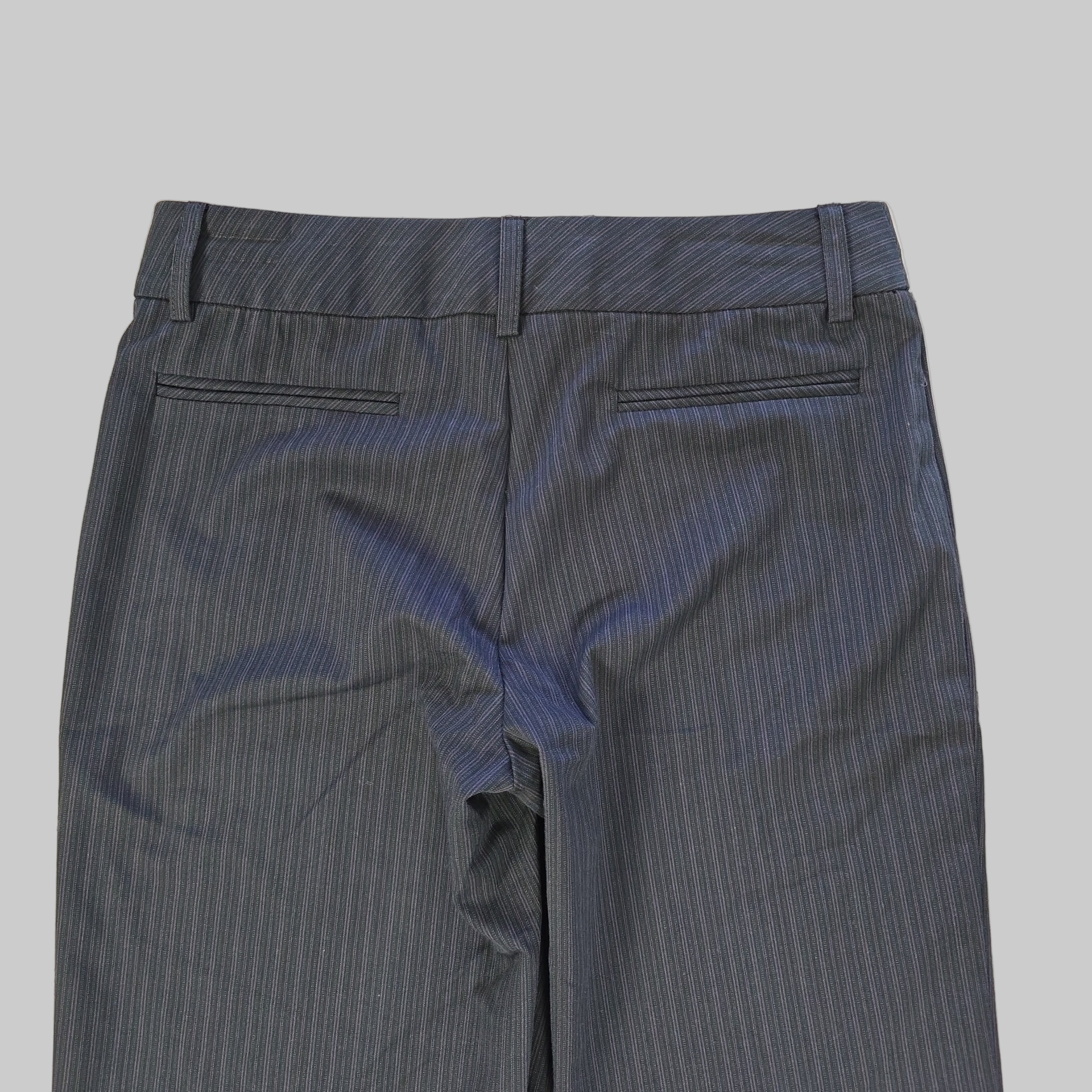 Dark gray pants on a tiled floor