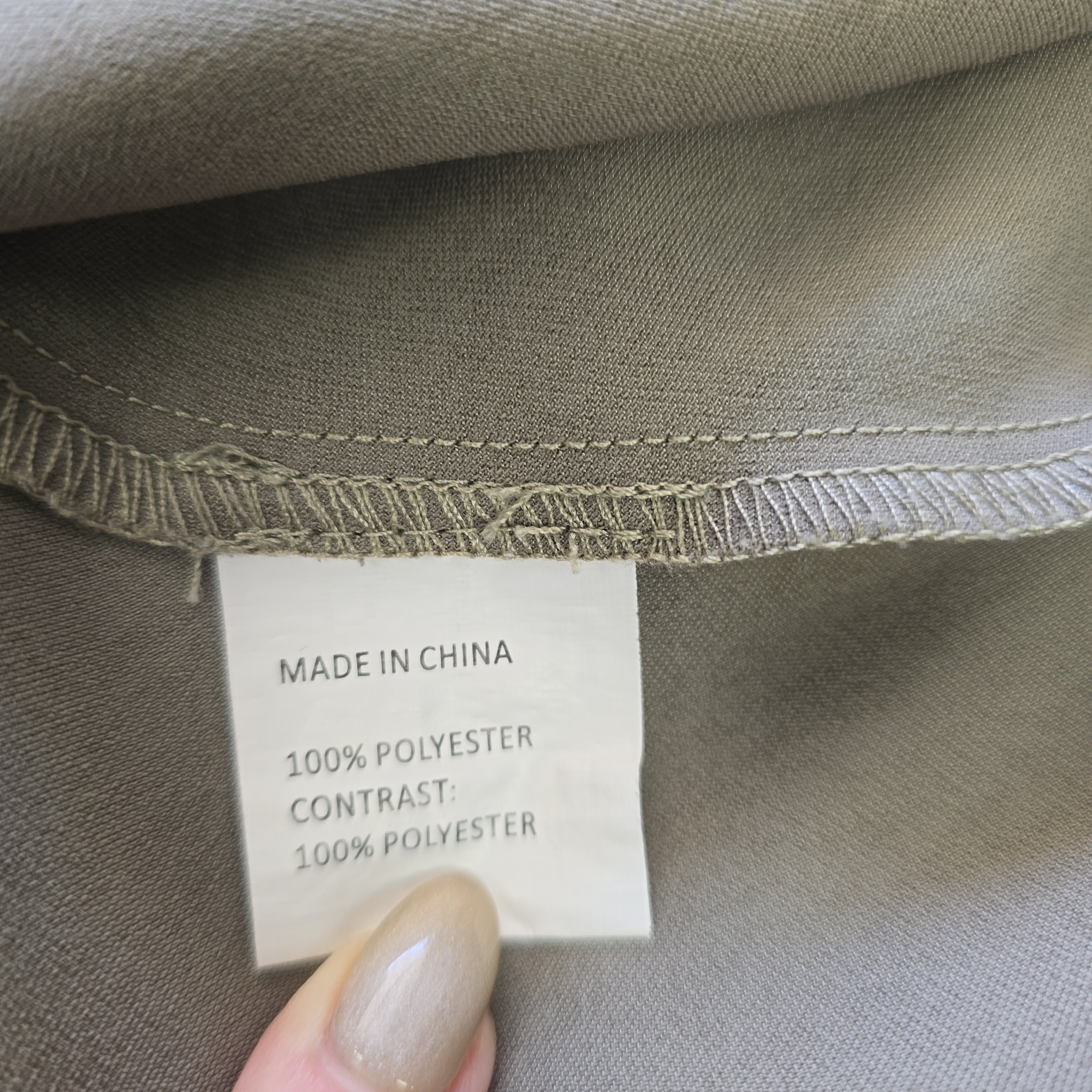 Close-up of a clothing label on a gray fabric background