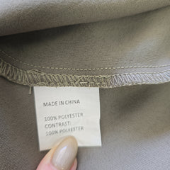 Close-up of a clothing label on a gray fabric background