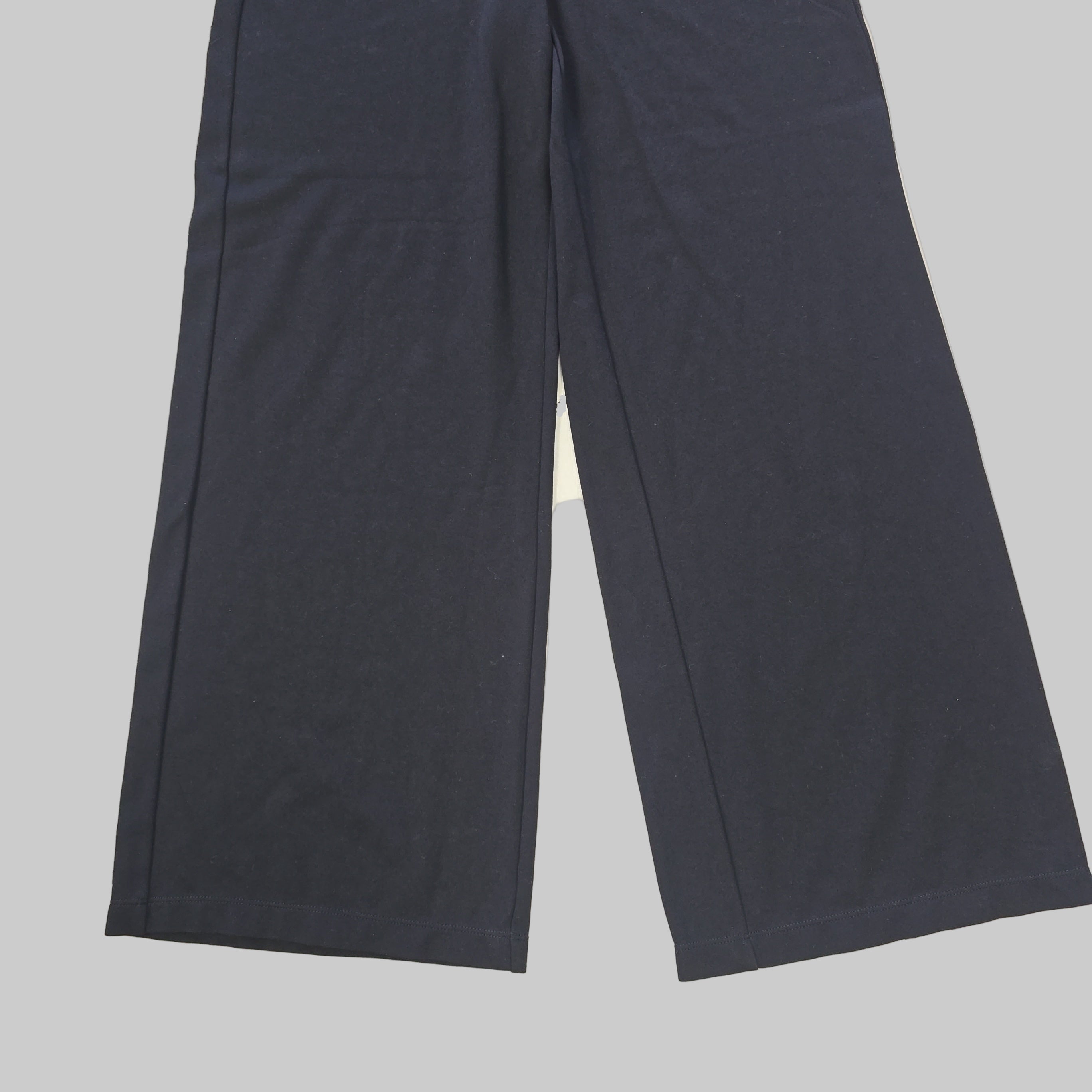 Two dark black pants on a tiled floor