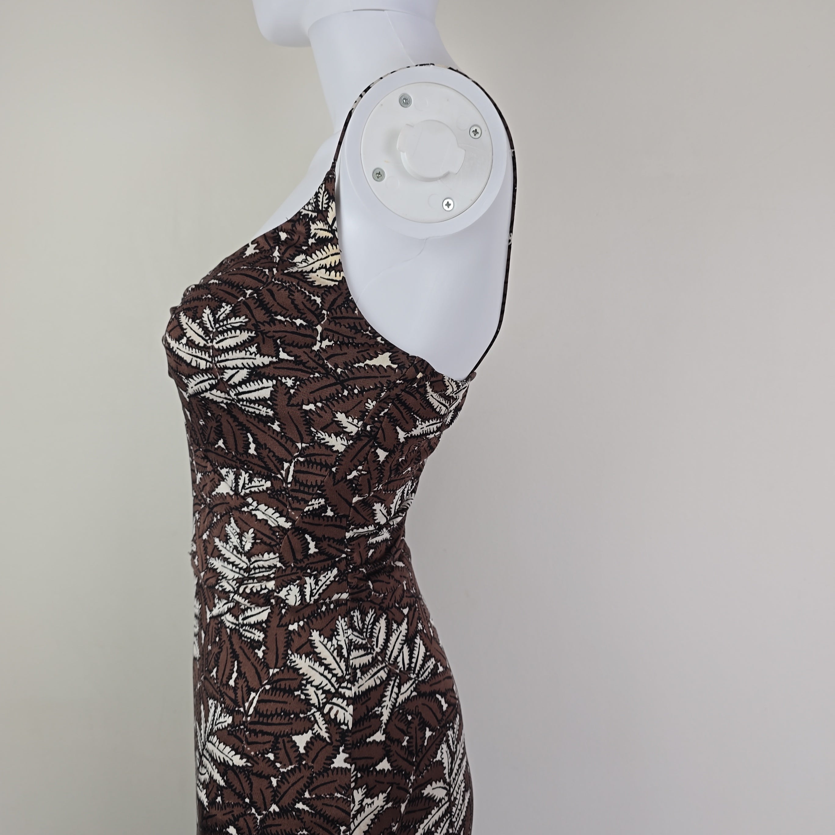 Brown patterned dress on a mannequin foot against a plain background