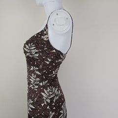Brown patterned dress on a mannequin foot against a plain background