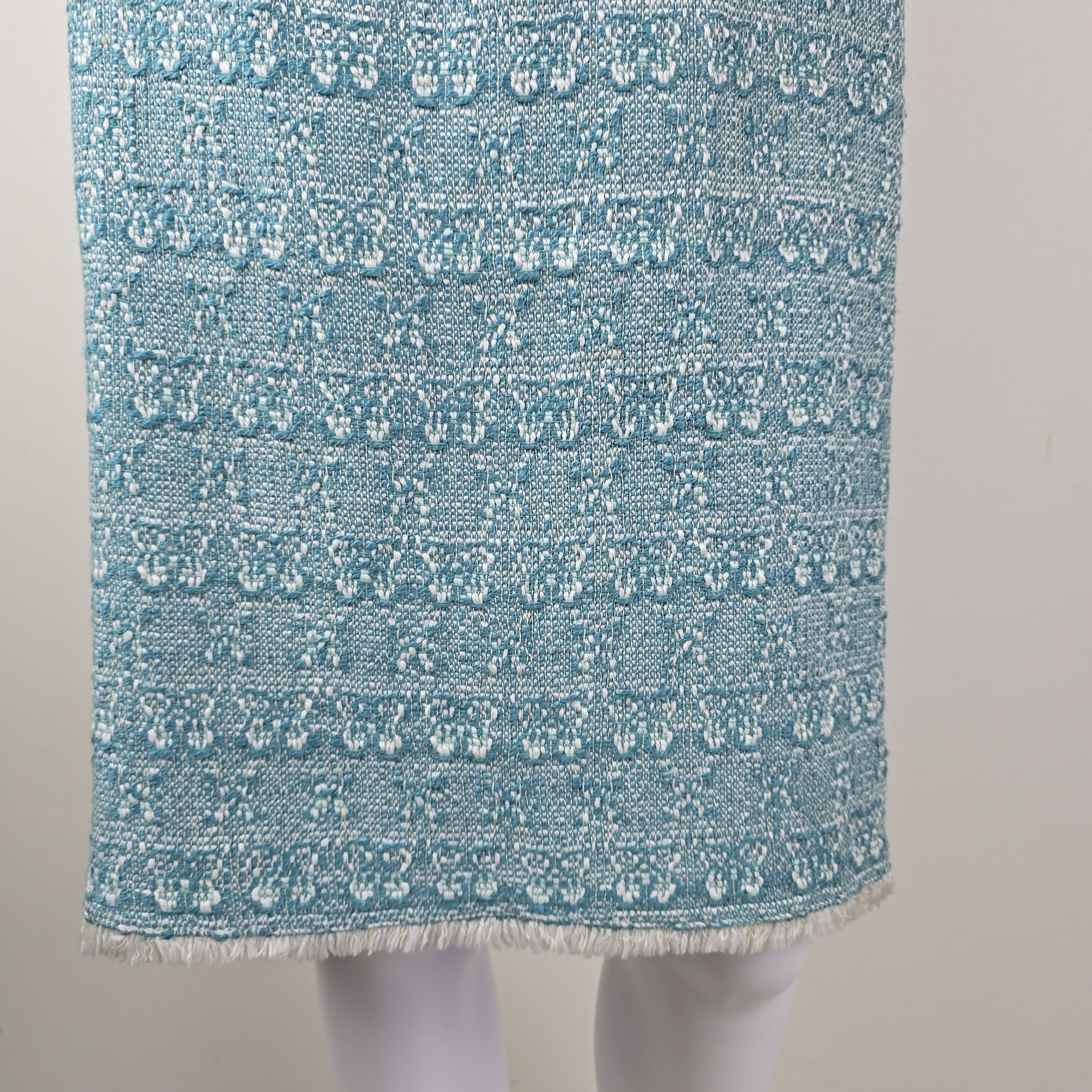 Textured blue fabric with white patterns on a light gray background