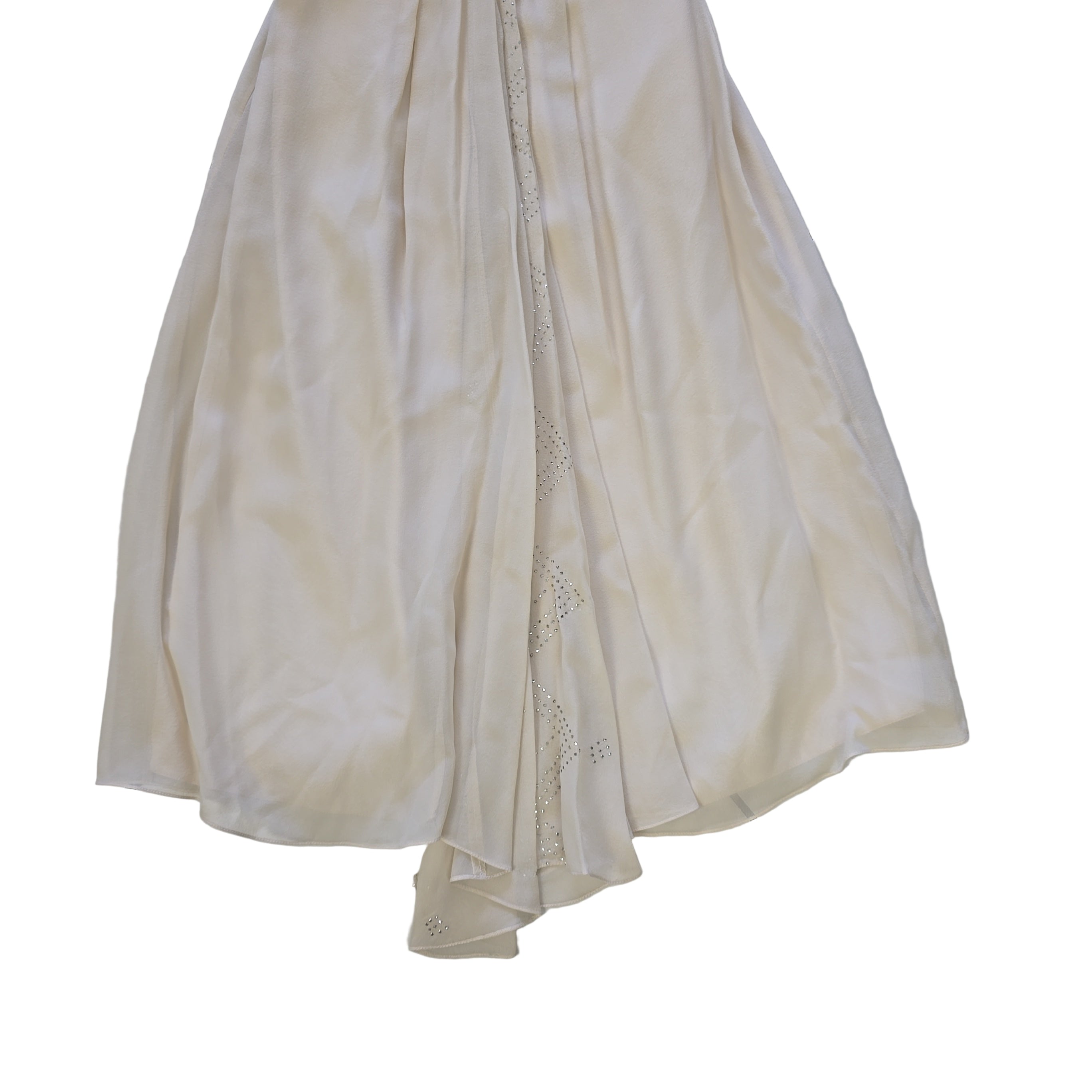 Folded white dress with lace trim on a tiled floor