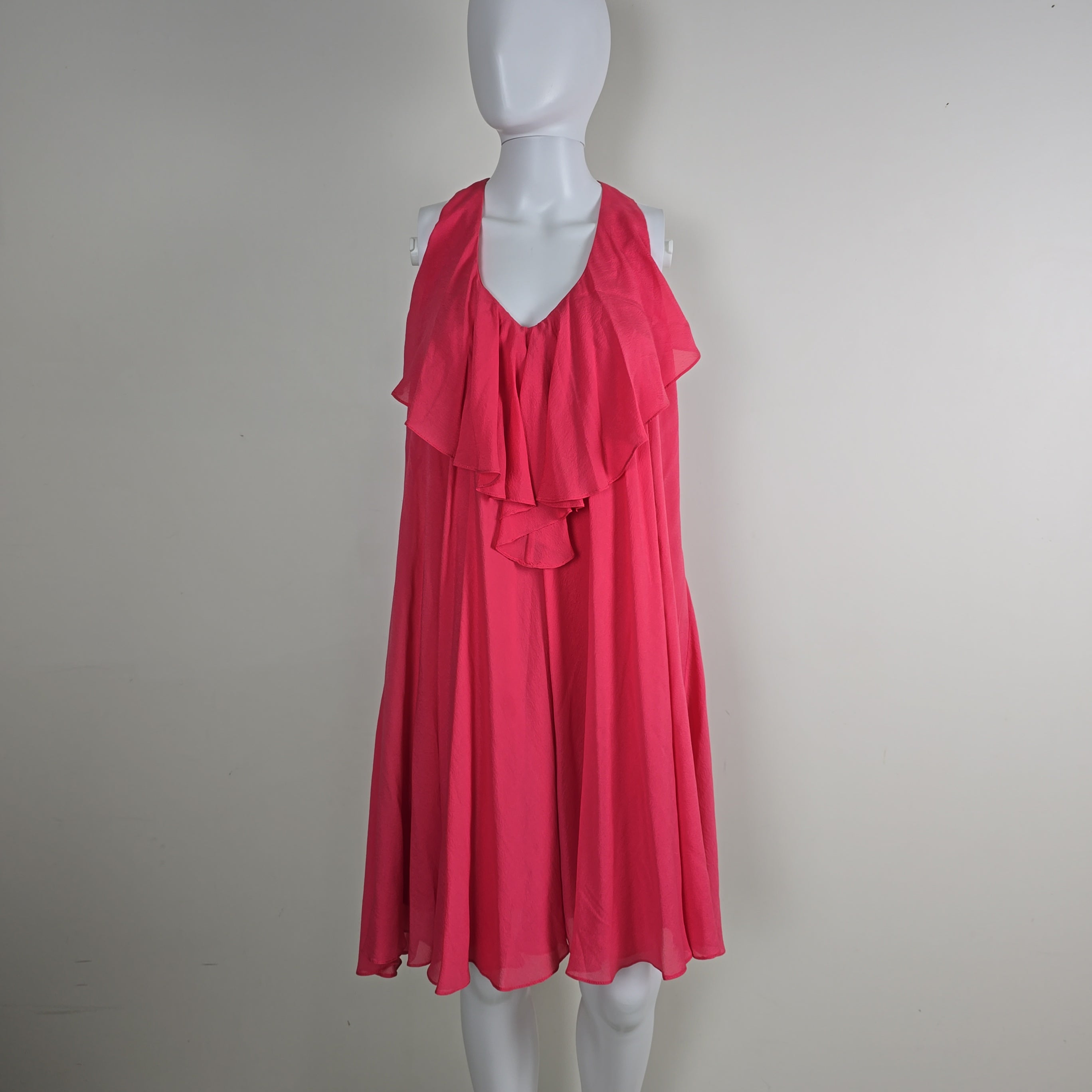 Red dress on a white mannequin against a plain background