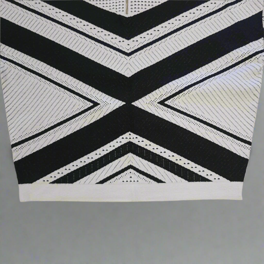 Black and white geometric patterned top on a tiled floor